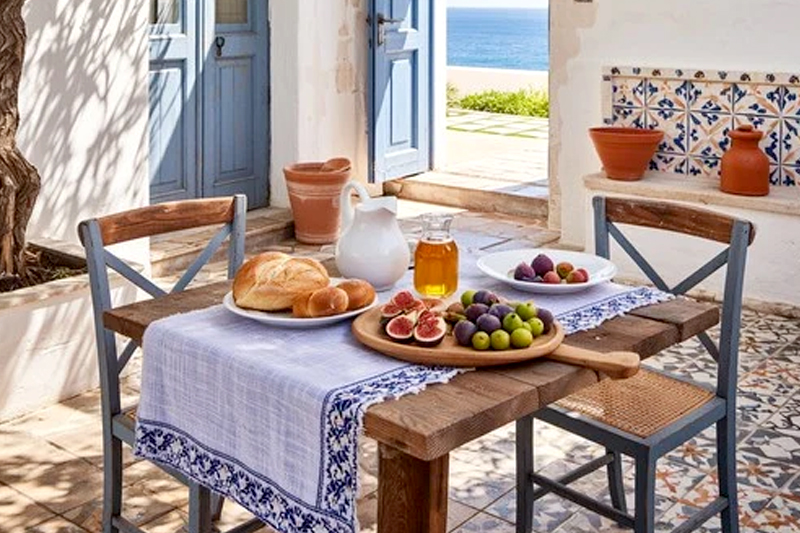 Mediterranean-inspired home decor with ceramic bowls, vases, rugs, and warm lighting creating a cozy interior atmosphere