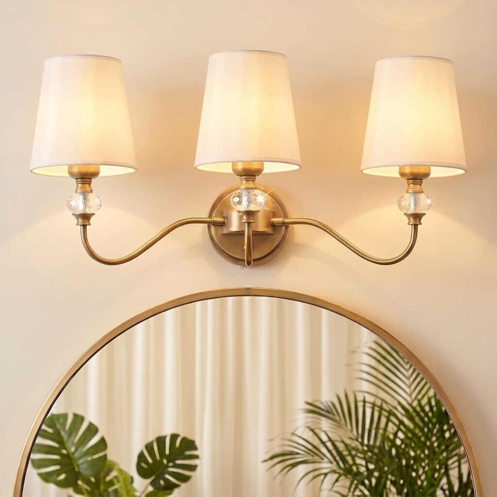3-light vintage bathroom vanity light brass finish with white fabric shades and crystal accent